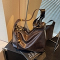 Sac hobo vintage en cuir marron foncé avec détails dorés et breloque tressée - café