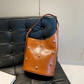 Secchiello in pelle marrone con borchie a sfera d'argento e finitura in cera su divano in pelle - Marrone