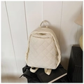 Détail d'un sac à dos matelassé beige montrant le motif de losanges et zip métallique - Blanc