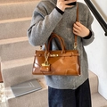 Brown faux leather tote bag with gold hardware and mini pouch shown on stairs - Brown
