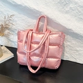 Pink quilted down tote bag with metallic satin finish for women in a studio setting - Pink