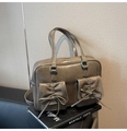 Dettaglio della borsa in pelle verniciata marrone con tasche frontali e fiocchi eleganti - Grigio