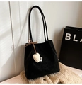 Gros plan du cabas noir mat avec breloque cœur sur un tissu beige doux et texturé - Avec Pendentif / Noir