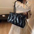 Glänzende schwarze Leder-Shopper mit Schultergurten, getragen von einem Model im Trenchcoat - 38*11*24 / Schwarz