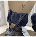 Detail van de donkere denim textuur en de metalen ritsen op de crossbody draagtas - Donkerblauw