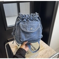 Primer plano de bolso tipo cubo de mezclilla azul con hebilla plateada y pliegues - Azul cielo
