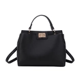 Retro black leather tote bag with gold twist lock and adjustable shoulder strap on white base - Black