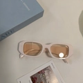 Retro rectangular sunglasses with cream thick frame and light brown lenses on a blue book - Beige Champagne