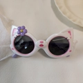 Detailed view of white cat-shaped kids sunglasses with pink ears and purple flower decoration - White