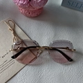 Detail of rimless sunglasses featuring diamond-cut edges and golden cheetah metal temples - Dusty Pink