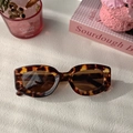 Vista plana de gafas de sol retro de carey con lentes marrones en fondo blanco - Estampado de leopardo