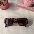 Detail of tortoise shell square sunglasses with dark lenses on a lifestyle desk setup - Leopard Print