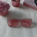 Detail van een roze vierkante zonnebril met strassteentjes en roze glazen glazen - Roze