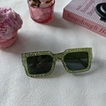 Détail de lunettes de soleil carrées vertes ornées de strass et verres foncés - Vert