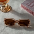Détail de lunettes de soleil carrées champagne translucide avec verres bruns sur fond blanc - Champagne
