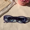 Stylish translucent purple cat-eye sunglasses with blue lenses on a stone surface - Blue