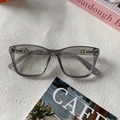 Detalle de gafas de resina gris púrpura con elegantes bisagras metálicas doradas en forma H - Gris