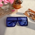 Detailopname van blauwe strassteentjes op een oversized vierkante zonnebril met donkere glazen - Koningsblauw