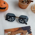 Close-up detail of pumpkin-shaped cutout lenses on rimless Halloween gold party sunglasses - Large Pumpkin Black