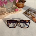 Detail of tortoise shell square frames with gold metal accents on textured background - Cream Marbled Clear Lens