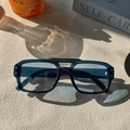 Classic aviator sunglasses with black frame and blue tinted lenses in natural sunlight - Blue
