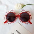 Red flower shaped kids sunglasses with round grey lenses on a white textured background - Red Frame Black Lens