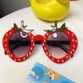 Red strawberry shaped kids sunglasses with white polka dots and green leaf accents - Red