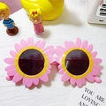 Pink and yellow daisy shaped sunglasses with round dark lenses for kids' fashion wear - Pink