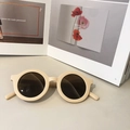 Beigefarbene runde Kinder-Sonnenbrille mit mattem Finish und braunen Gläsern - Rosa