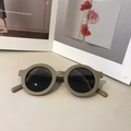 Retro runde Kinder-Sonnenbrille in Matt-Khaki mit dunklen Gläsern auf Magazin - Grau