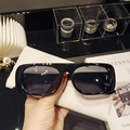 Primer plano de gafas de sol negras rectangulares con estuche de cuero granulado blanco - Montura Negra Lente Gris