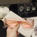 Gafas de sol rosa transparente apoyadas sobre un estuche de cuero blanco - Lente Rosa Transparente
