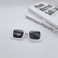 Flat lay of white rectangle retro sunglasses on books with UV protective dark lenses - White Frame / Black Lens