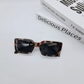 Flat lay of vintage tortoise shell sunglasses with rectangle frames on minimalist books - Tortoise with Gray Lens
