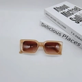 Detail view of vintage translucent amber rectangle sunglasses on books with brown lenses - Jelly Pink