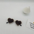 Detailansicht der herzförmigen Sonnenbrille in Creme mit Spitzenrand und Farbverlauf - Weißer Rahmen Graue Gläser