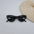Dettaglio di occhiali da sole neri cat-eye con eleganti rivetti in metallo argentato sulla montatura - Nero Lucido