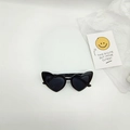 Détail de lunettes de soleil noires en forme de cœur sur fond blanc avec une carte - Monture Noire Verres Gris