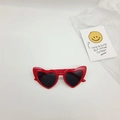 Close-up of red heart-shaped kids sunglasses with cat ear details and dark lenses - Red Frame Grey Lens
