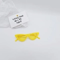 Detailed view of yellow cat-eye kids sunglasses on a clean white textured background - Yellow