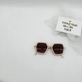 Detail view of pink diamond-frame kids sunglasses with gold hinges and dark lenses - Pink