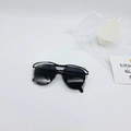 Close-up of modern black oversized kids' sunglasses with translucent grey frame details - Black Frame Grey Lens