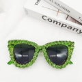 Vue détaillée de lunettes de soleil œil-de-chat ornées de strass en cristal vert - Vert