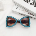 Primer plano de gafas de sol mariposa con pedrería azul y montura de carey elegante - Estampado de leopardo