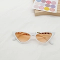 Detalle de gafas de sol retro cat-eye con montura blanca y lentes naranjas sobre tela - Montura Blanca Lente Naranja