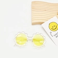 Detailaufnahme der gelben runden Gläser und des transparenten Blumenrahmens dieser Kindersonnenbrille - Transparentes Gelb