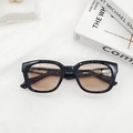 Detail view of vintage thick black sunglasses frames with brown lenses on white fabric - Black Frame Tea Lens