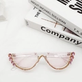 Close-up of pink rimless crescent sunglasses with sparkling rhinestones and clear lenses - Transparent Pink