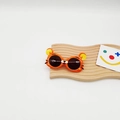 Détail de lunettes de soleil pour enfants en forme de tigre orange sur socle - Orange