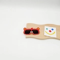 Dettaglio di occhiali da sole per bambini a forma di orso rosso su supporto in legno - Rosso